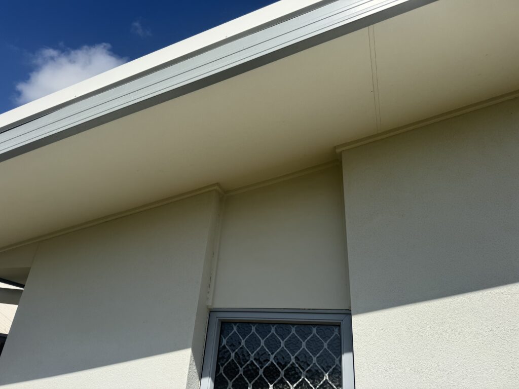 Clean house eaves and a rendered wall beneath a roof overhang in Bucasia.