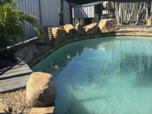  Clean decorative rocks surrounding a backyard swimming pool in Mackay