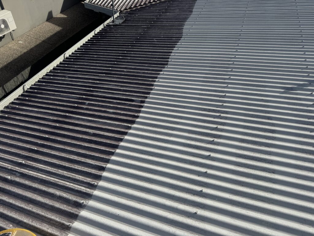 Roof cleaning in progress in Mount Pleasant, with dark uncleaned roofing on the left and a clean light-grey section on the right