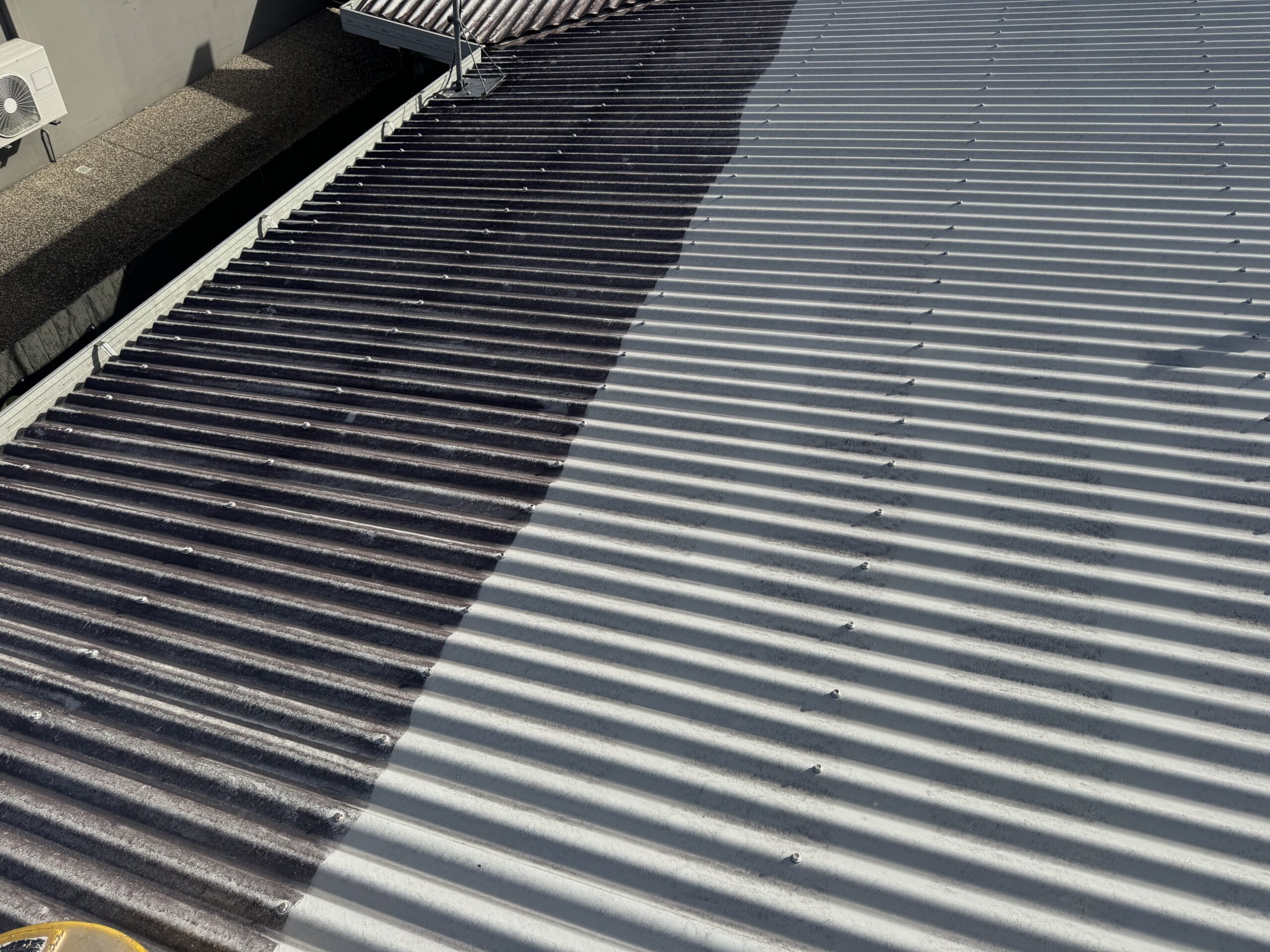 Roof cleaning in progress in Mount Pleasant, with dark uncleaned roofing on the left and a clean light-grey section on the right