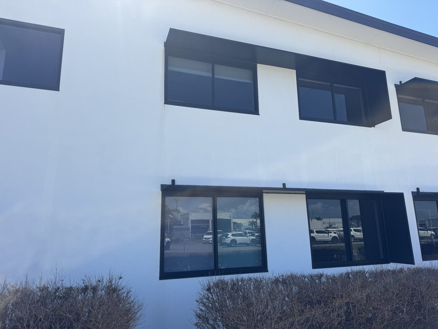 Light-coloured exterior walls and dark window shades at the CQ Rescue building
