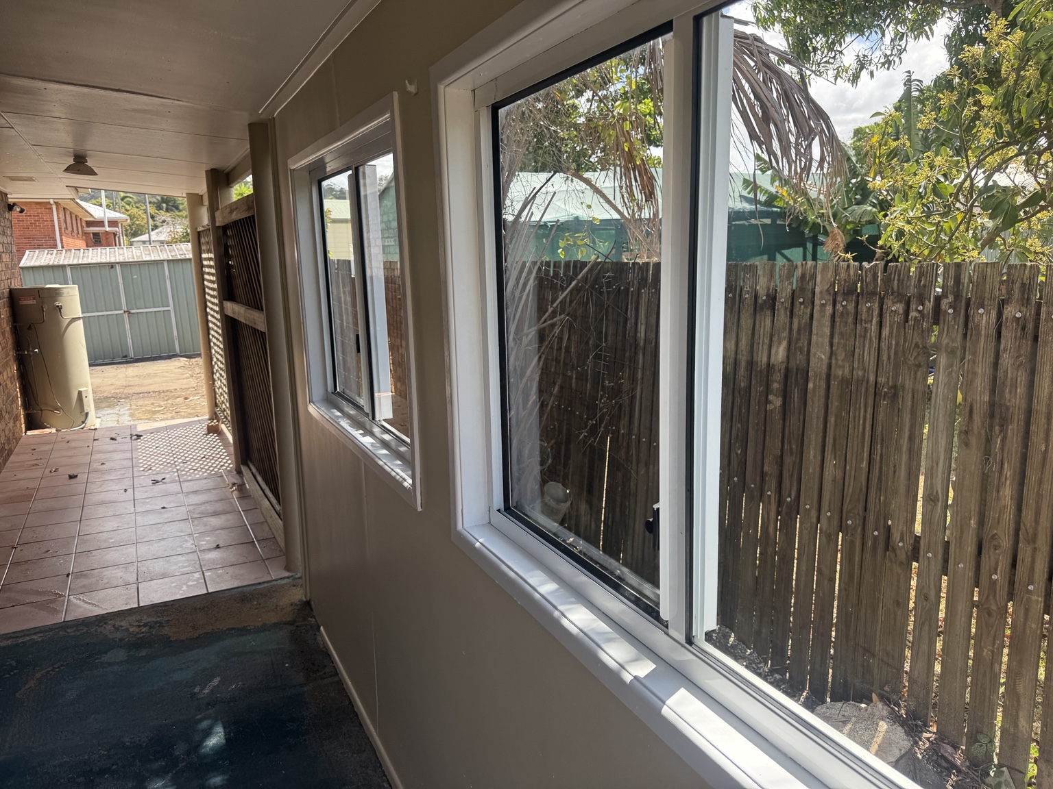 Windows, painted wall and covered side area at the Sarina home after washing