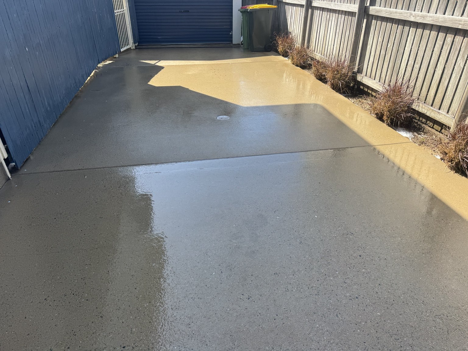Concrete driveway in Slade Point after pressure cleaning beside the shed