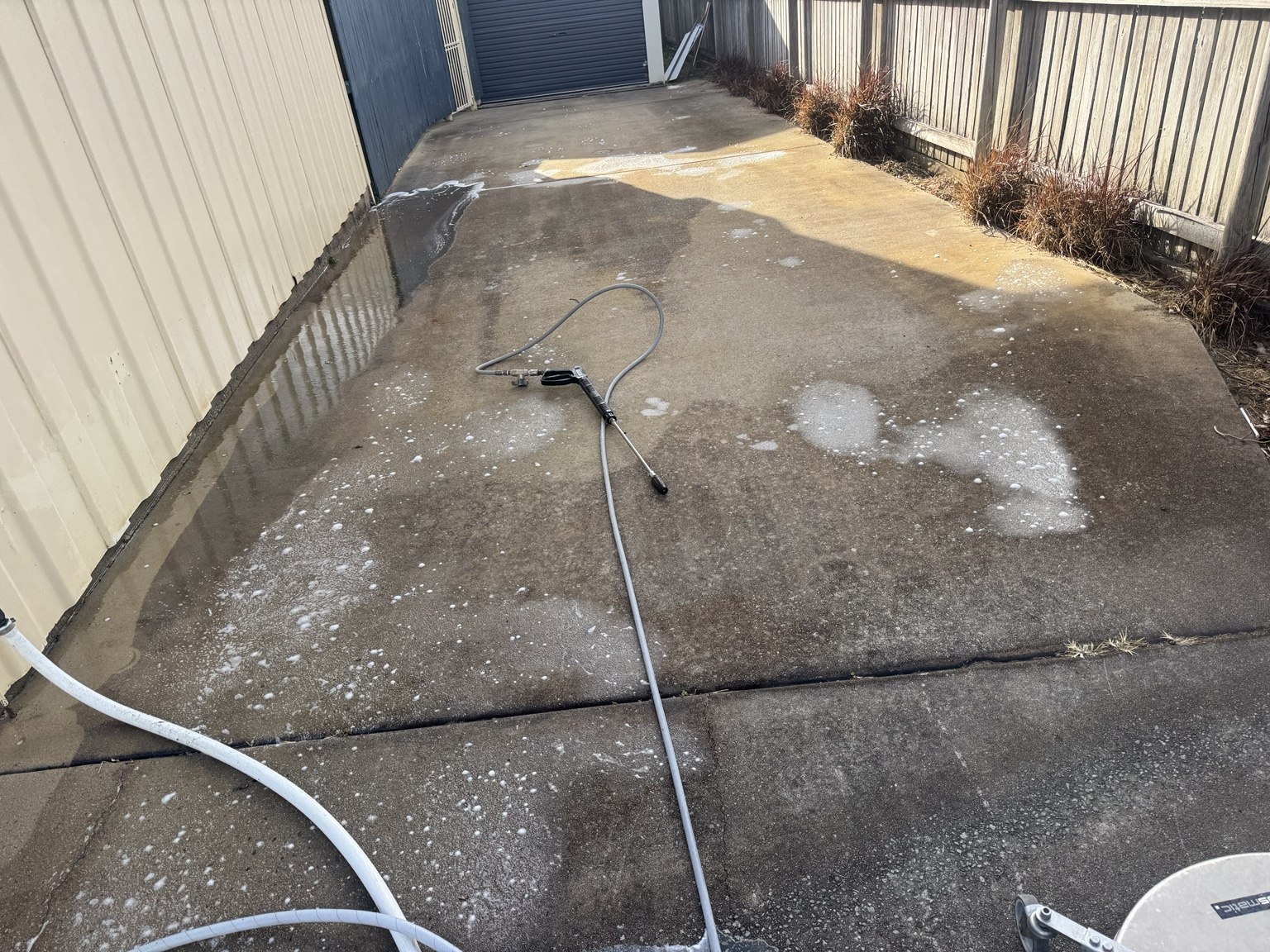 Dark and patchy concrete driveway in Slade Point before pressure cleaning