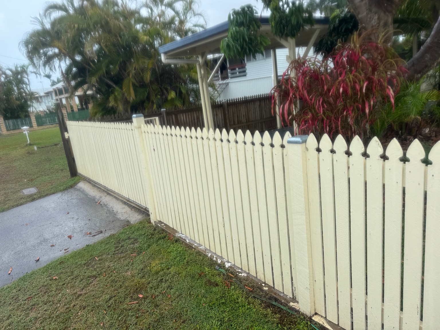 Cream painted picket fence and sliding gate at the East Mackay house-and-fence project