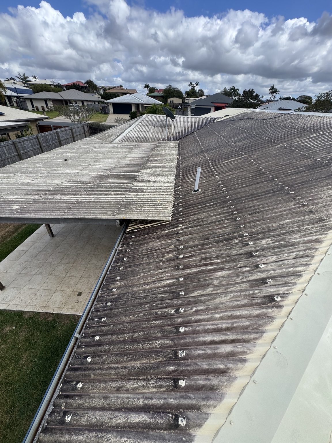 Dark staining and patchy build-up across the corrugated metal roof in Walkerston
